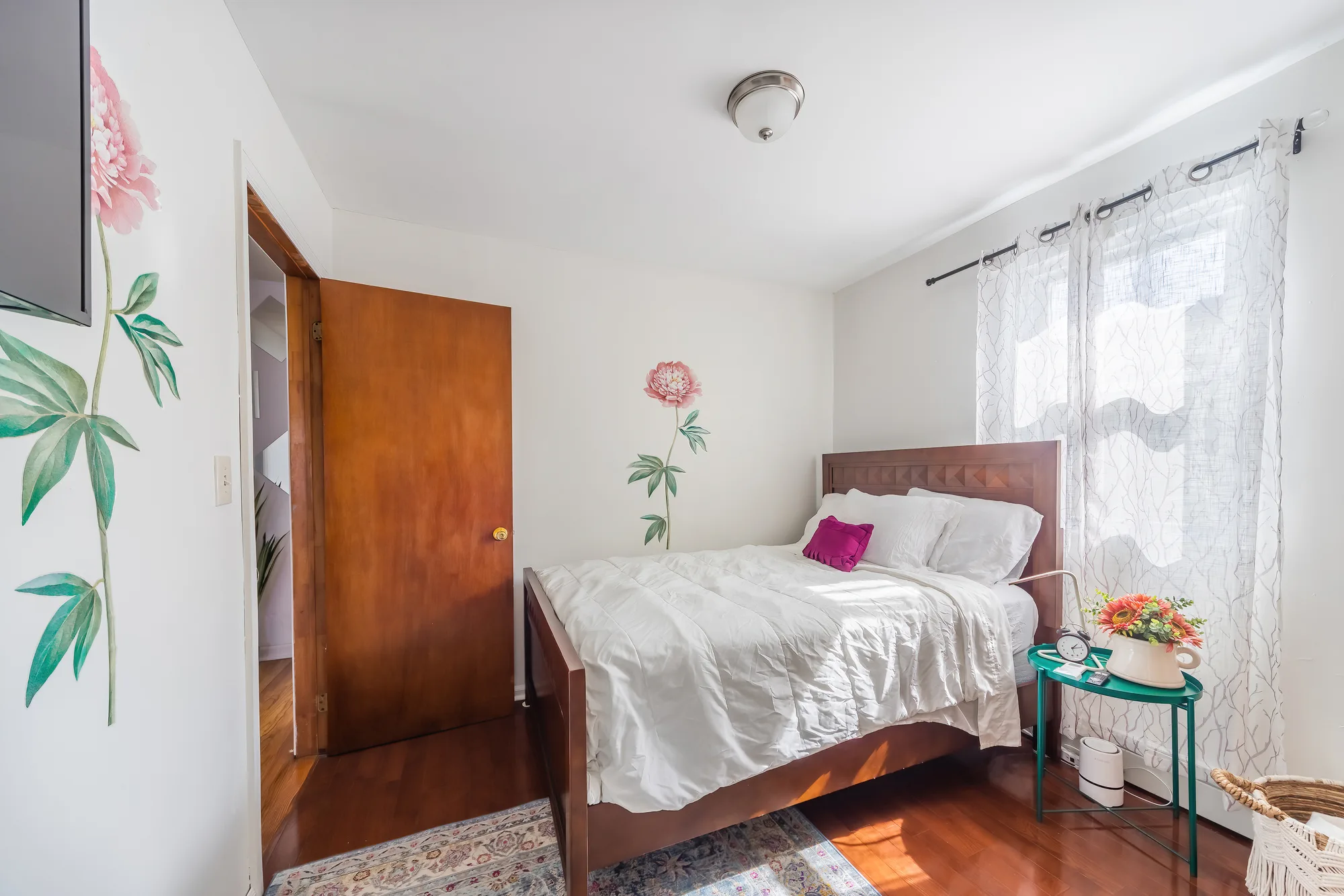 OpenDoors360 professional Airbnb photography of a furnished bedroom with wood bed frame and floral art in a short-term rental, the kind of lasting impression that drives more bookings