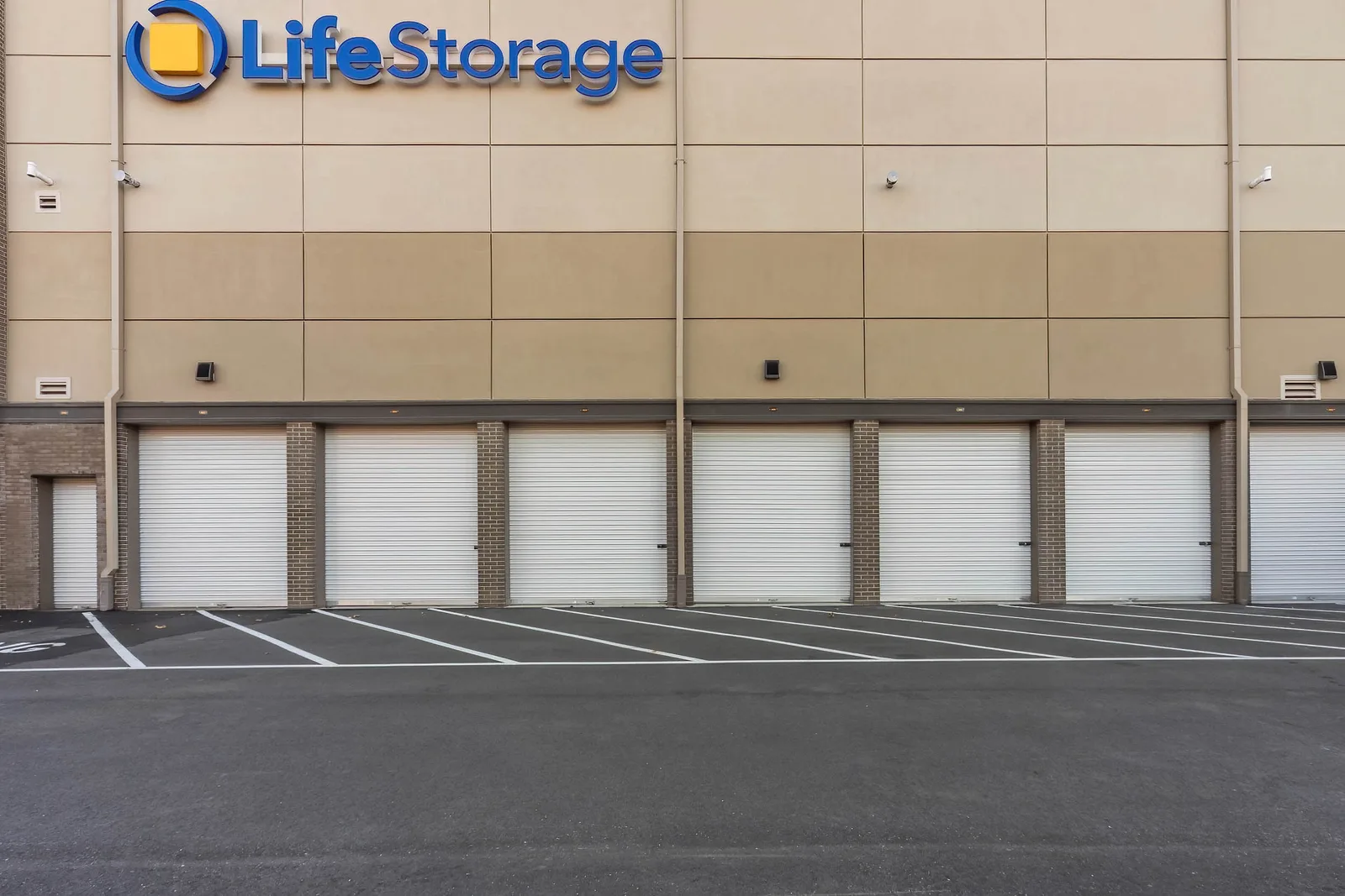 Drive-up storage units and striped loading bays at Life Storage in Glen Head, New York, commercial real estate photography, by OpenDoors360