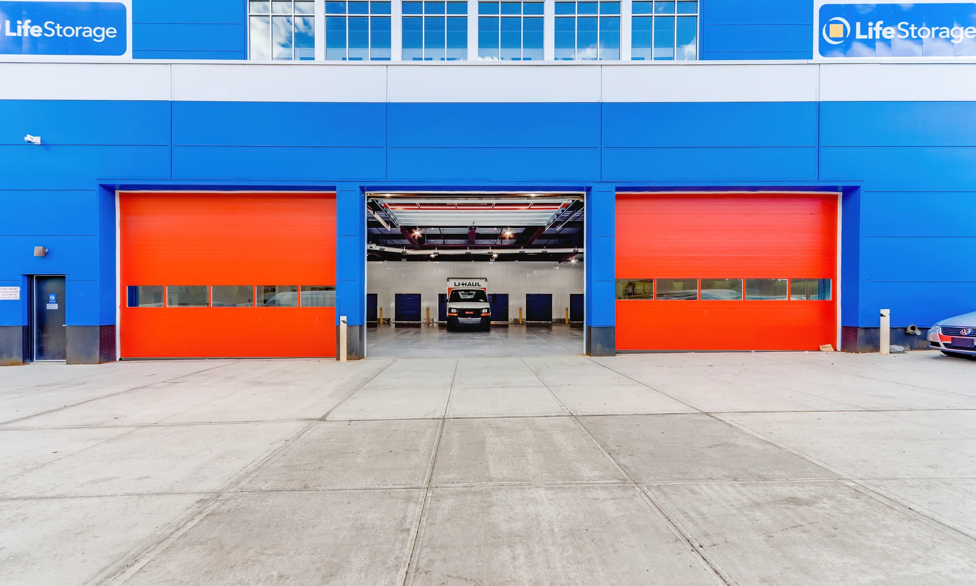 Twin orange drive-in loading doors with truck bay at Life Storage in Bushwick, Brooklyn, New York, real estate photography, by OpenDoors360