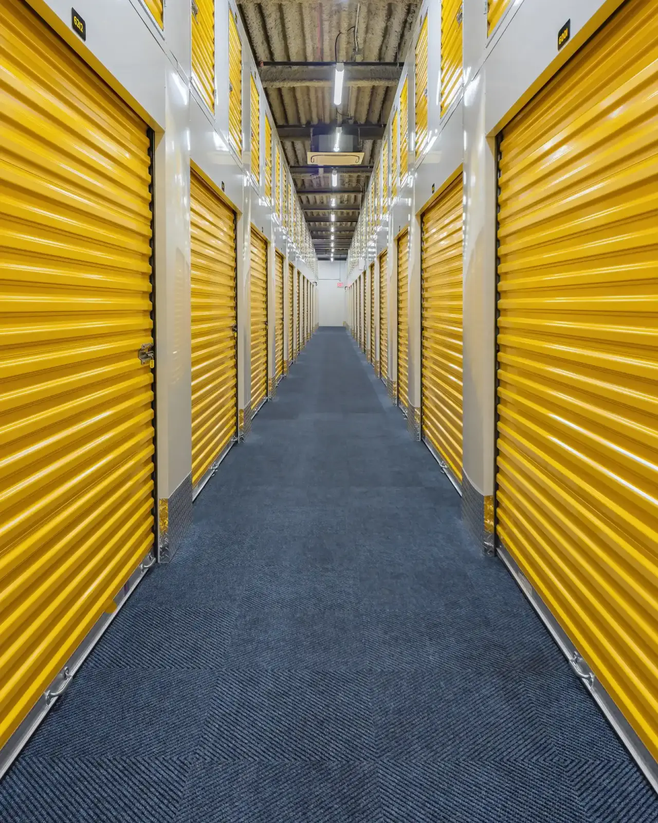 Interior corridor of a Staten Island commercial storage facility captured in HDR for New York City commercial real estate photography, with even light and a comprehensive view down the units