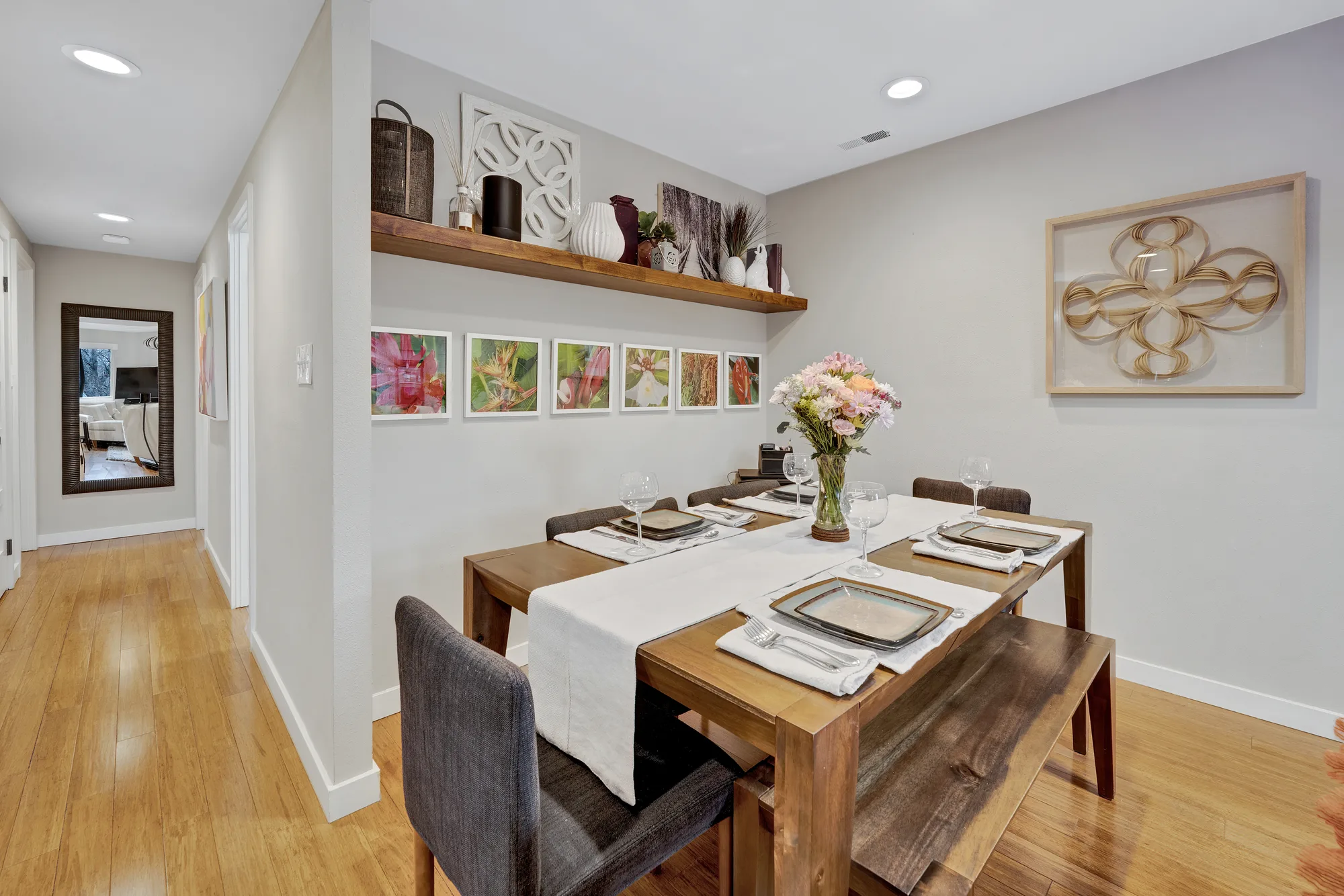 Staged dining room with wood table, floating shelf and gallery wall, real estate photography, by OpenDoors360