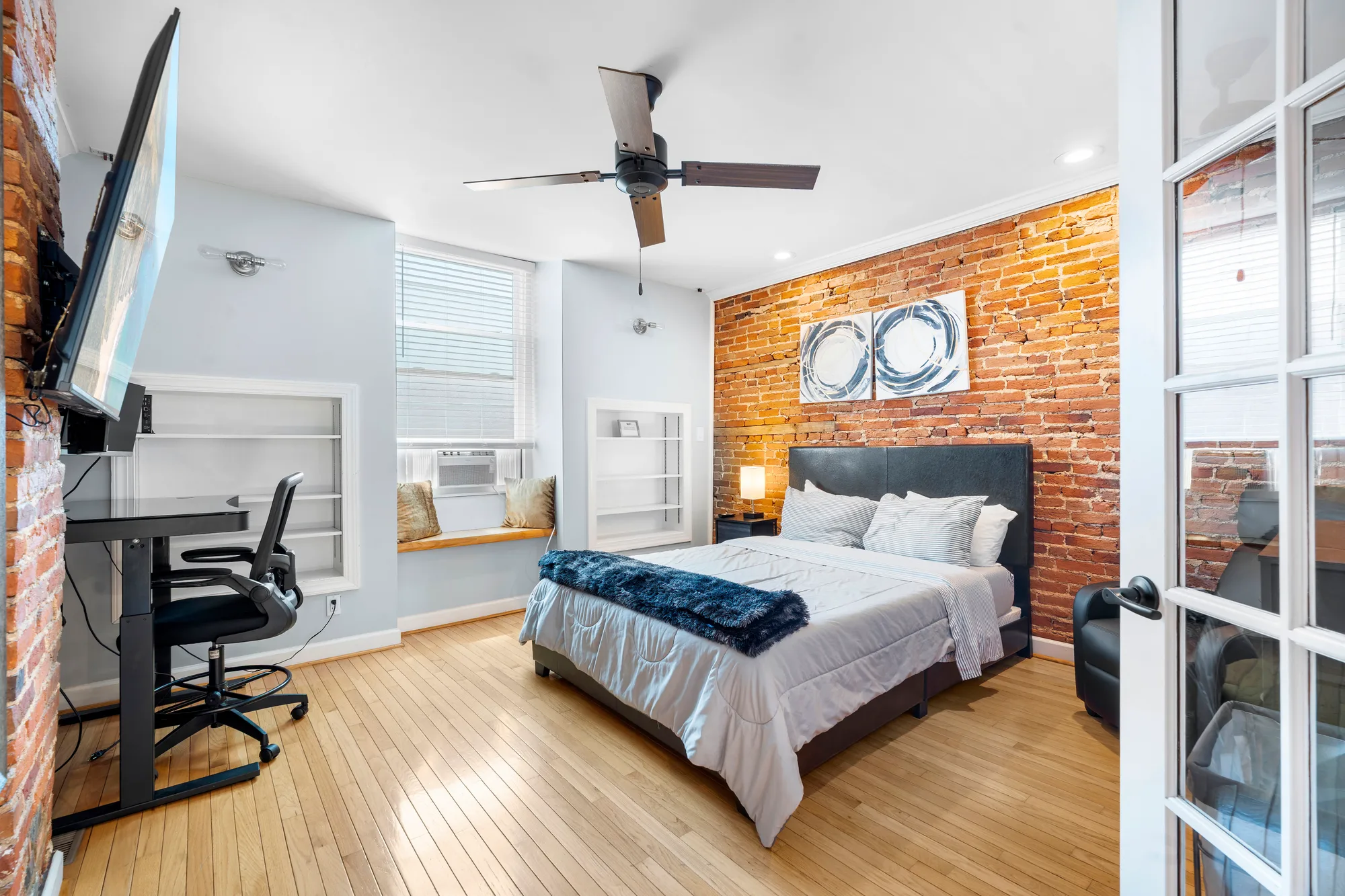 Bedroom with brick accent wall, desk and ceiling fan in Baltimore, MD, by OpenDoors360