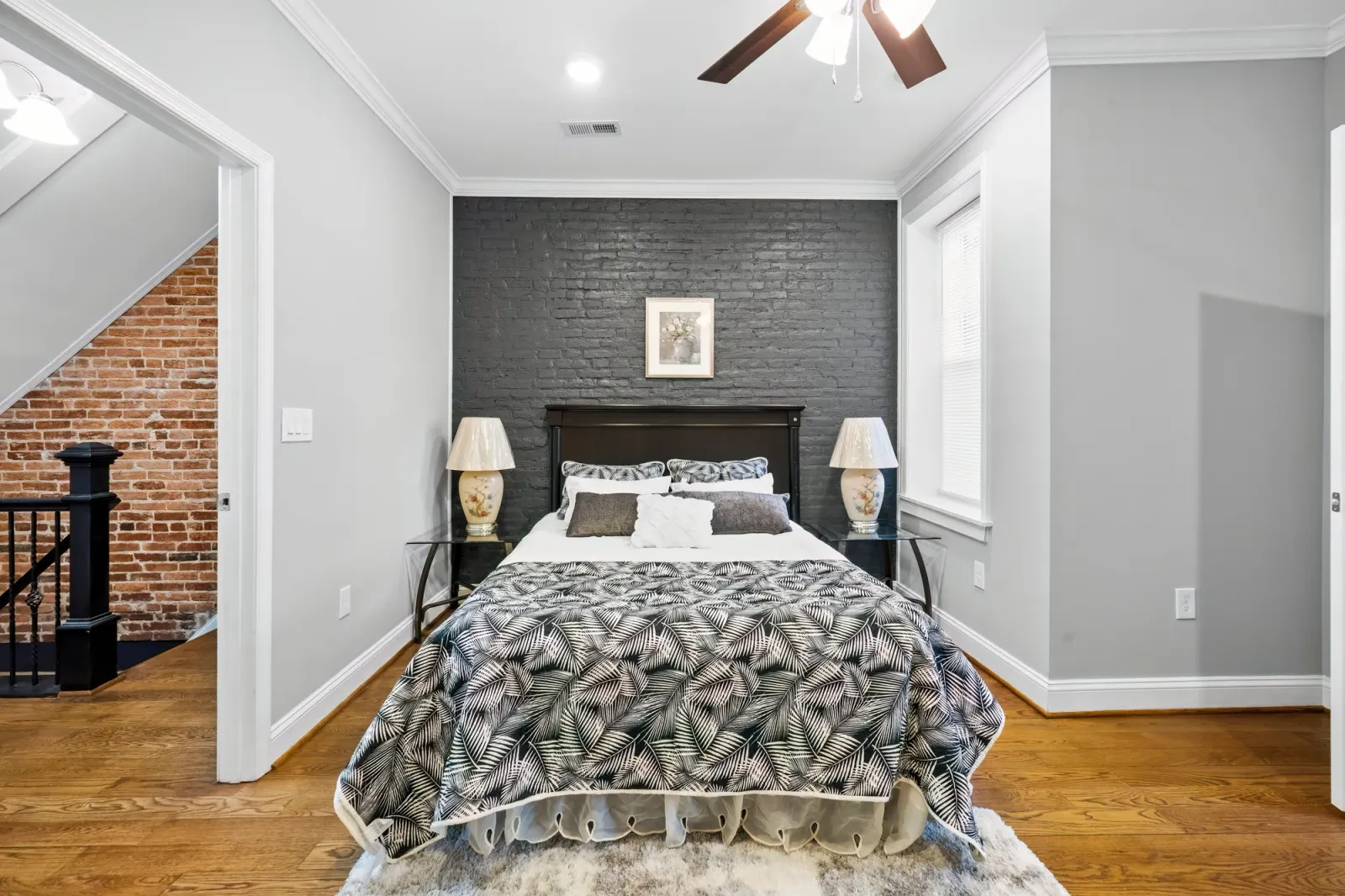 Bedroom with charcoal brick accent wall and floral bedding in Baltimore, MD, by OpenDoors360