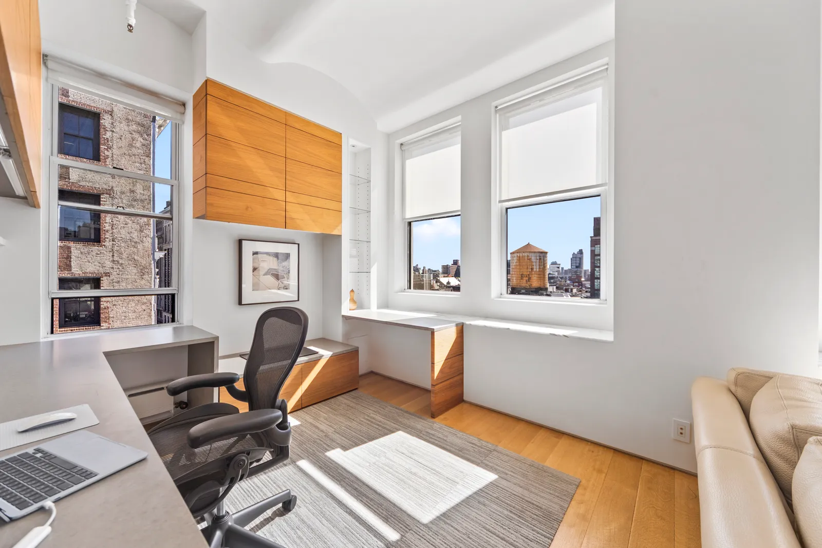Home office corner with a mesh desk chair and a window onto a SoHo water tower, part of a photo and video shoot by OpenDoors360