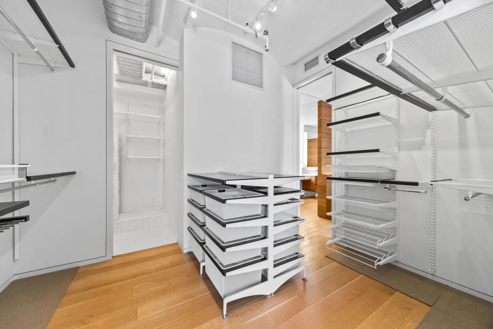 Walk-in closet with open shelving and a freestanding drawer unit in a Manhattan loft, by OpenDoors360