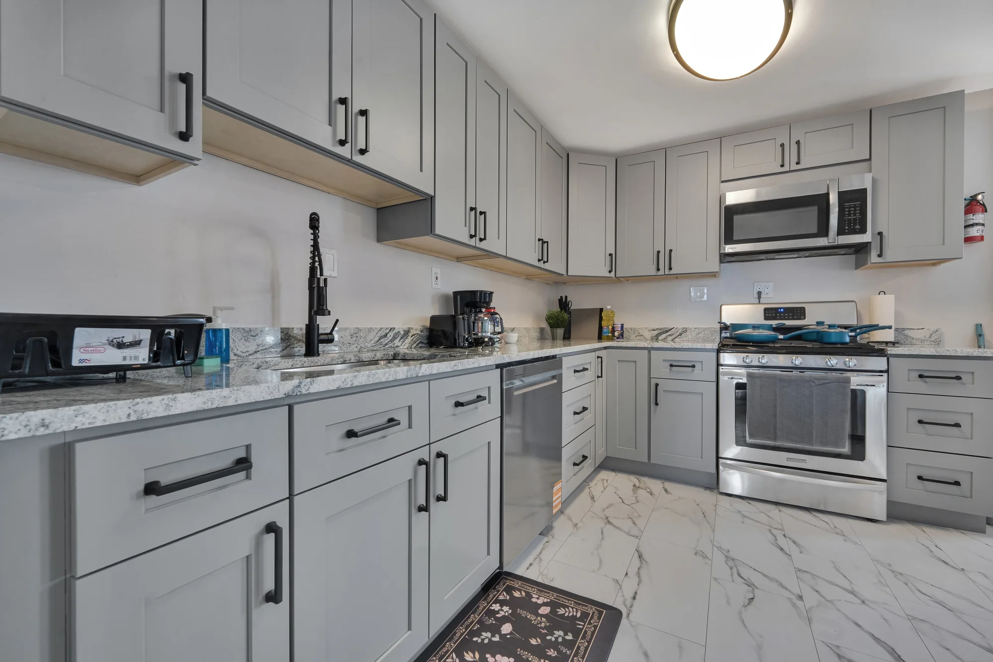Kitchen with gray cabinets, granite counters and stainless appliances in Baltimore, MD, by OpenDoors360