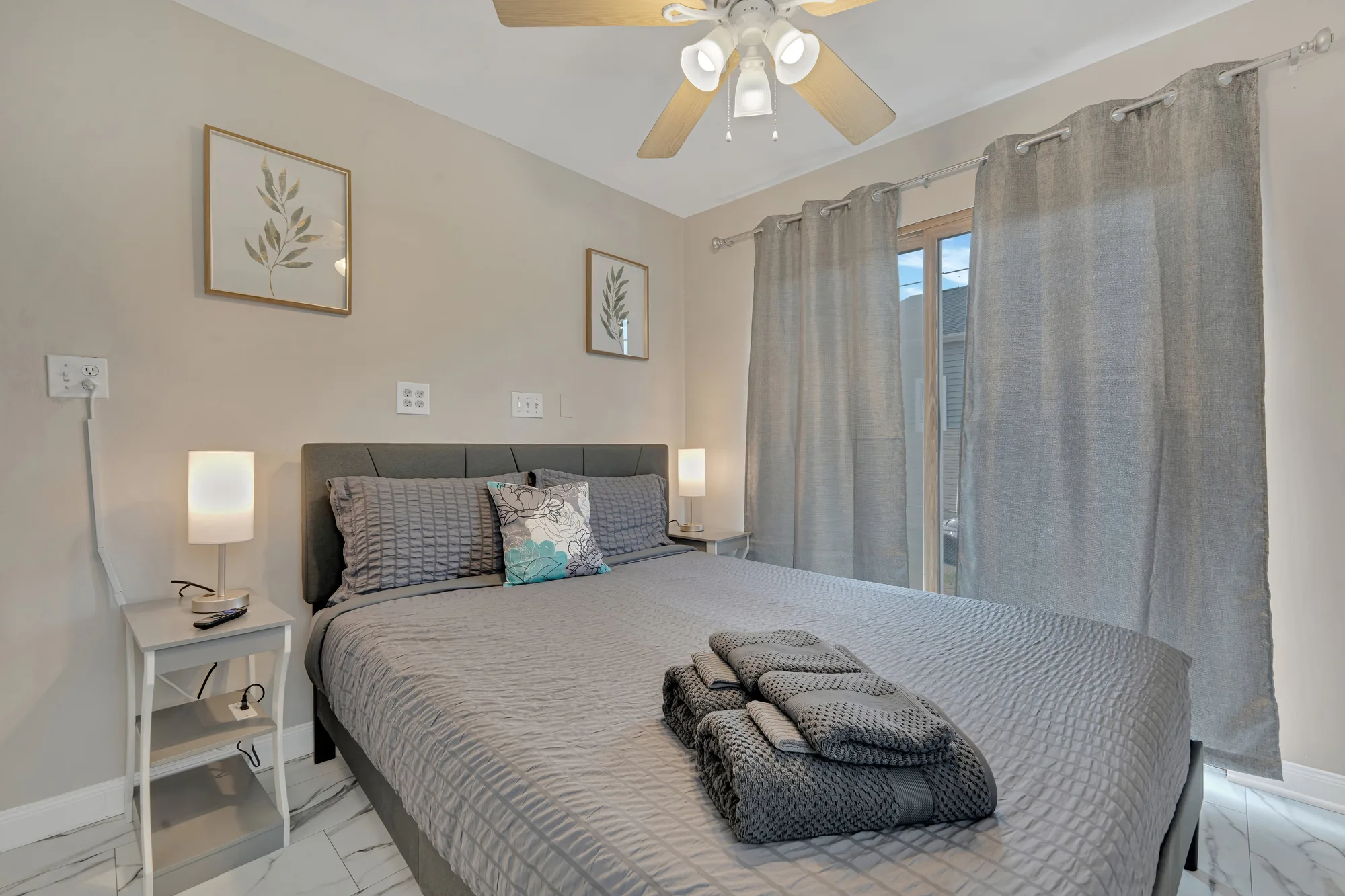 Gray-toned bedroom with sliding glass door and leaf wall prints in Baltimore, MD, by OpenDoors360