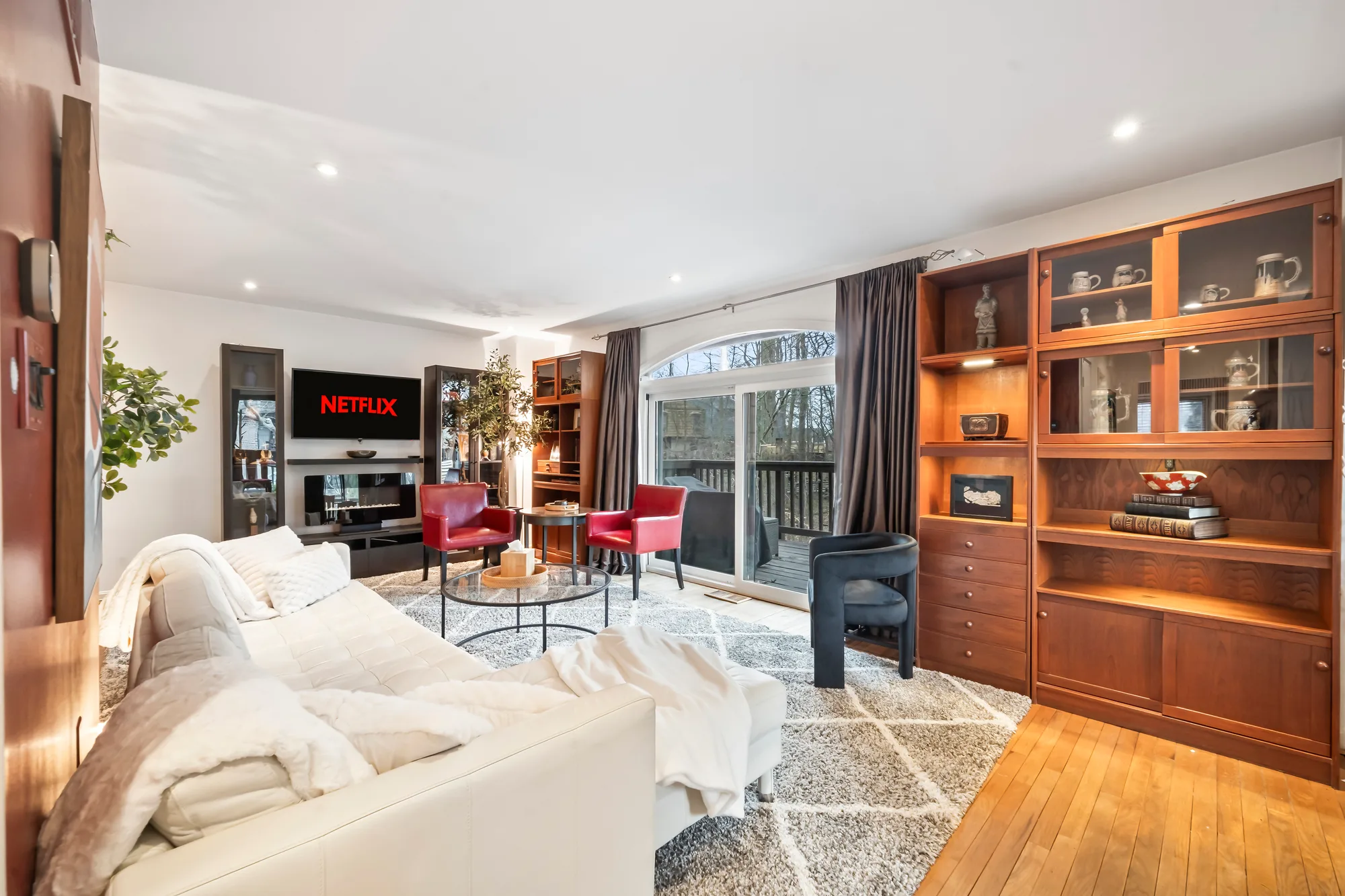 Living room with white sofa, red accent chairs and wood hutch in Northern Virginia, by OpenDoors360