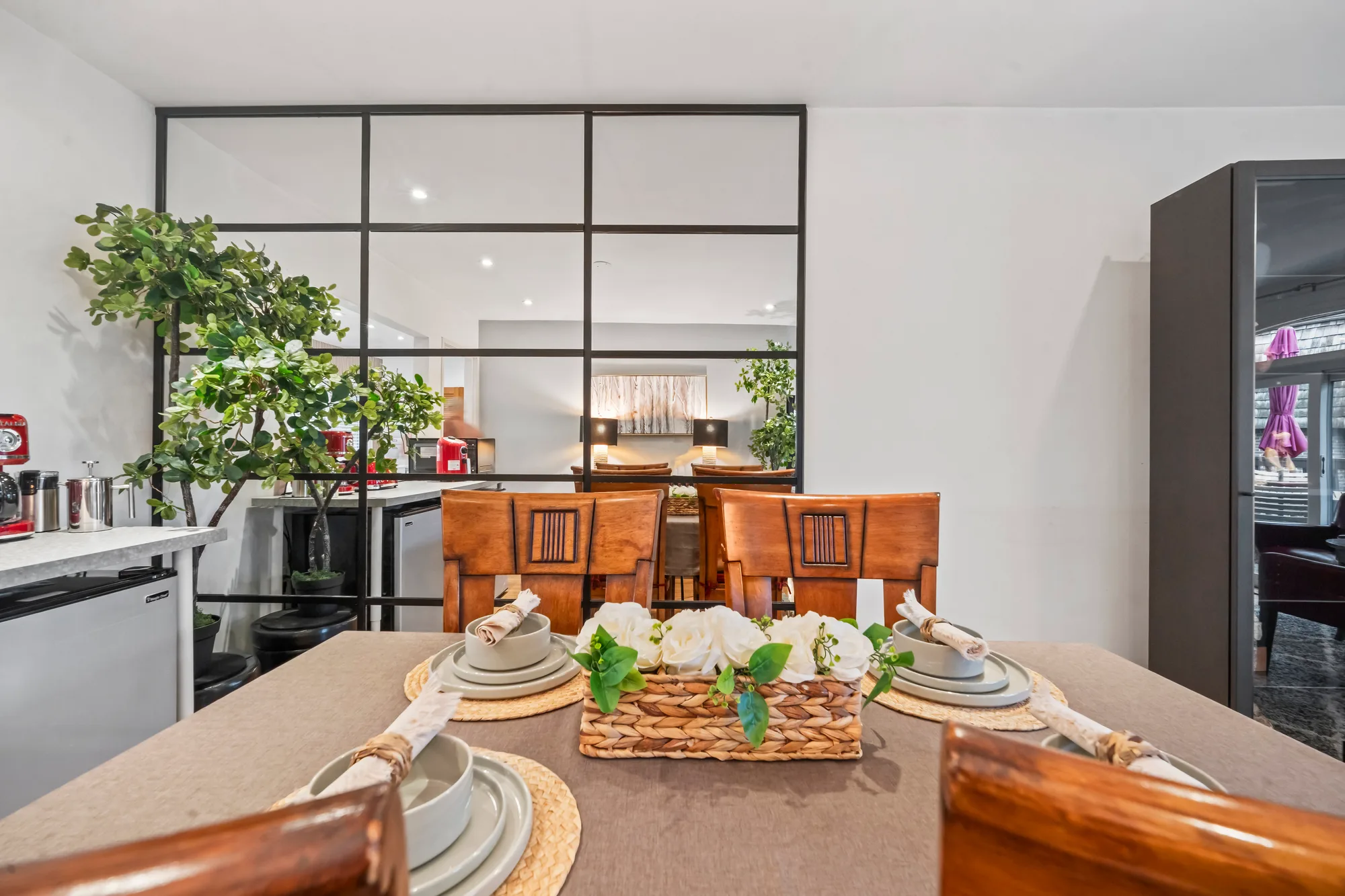 Dining table set with place settings beside glass partition wall in Northern Virginia, by OpenDoors360