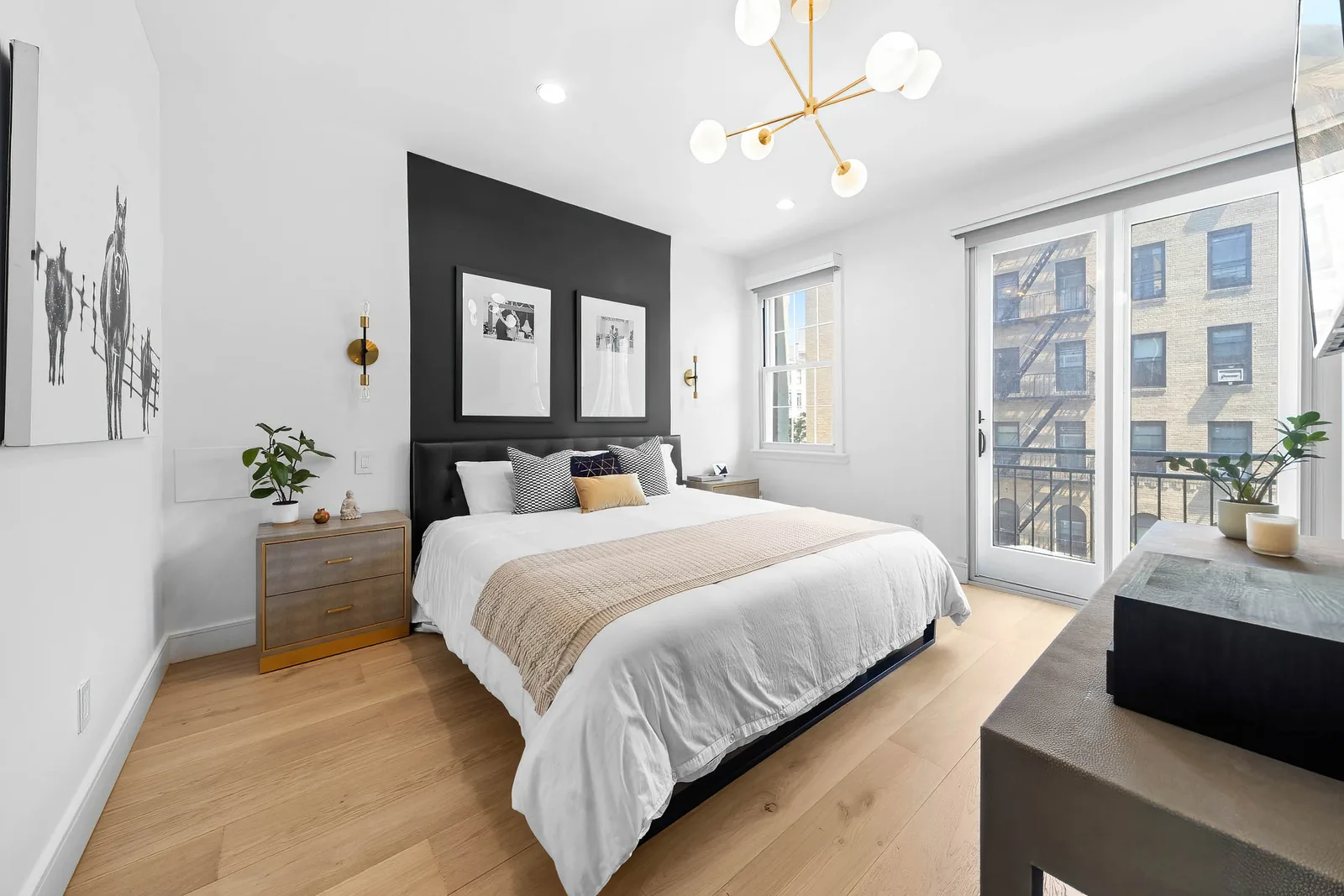 Bedroom with black accent wall, gold globe chandelier and balcony doors in NYC, by OpenDoors360