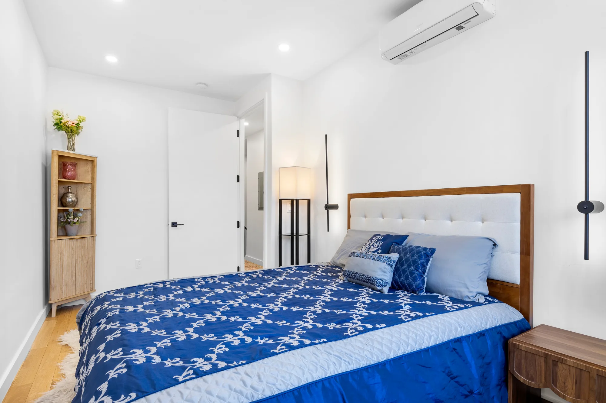 HDR bedroom photo of a New York City apartment with a wall-mounted mini-split, shot by a real estate photographer in NYC