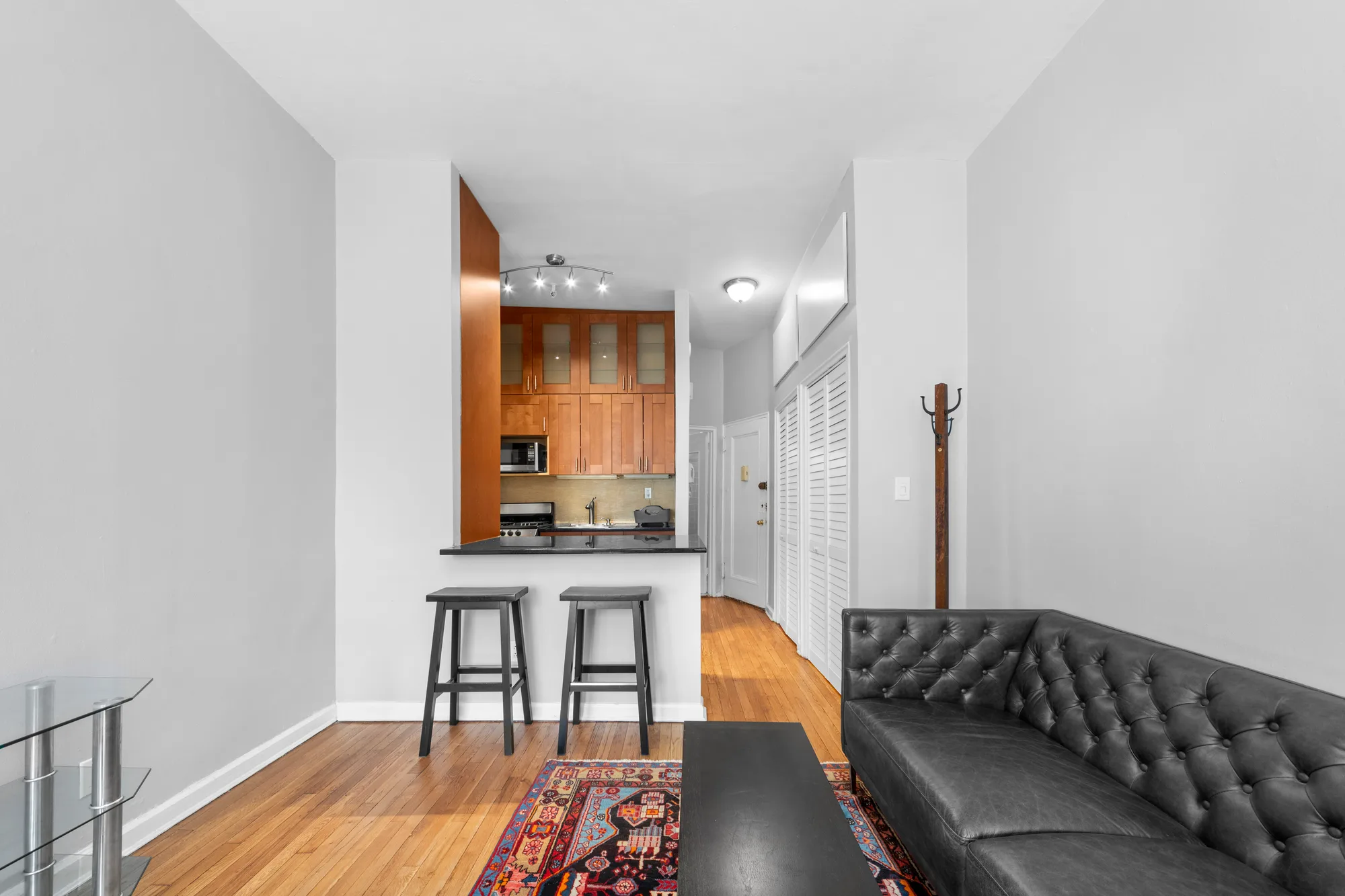 Galley kitchen opening to a living room shown along the walkthrough path for a real estate video in New York City