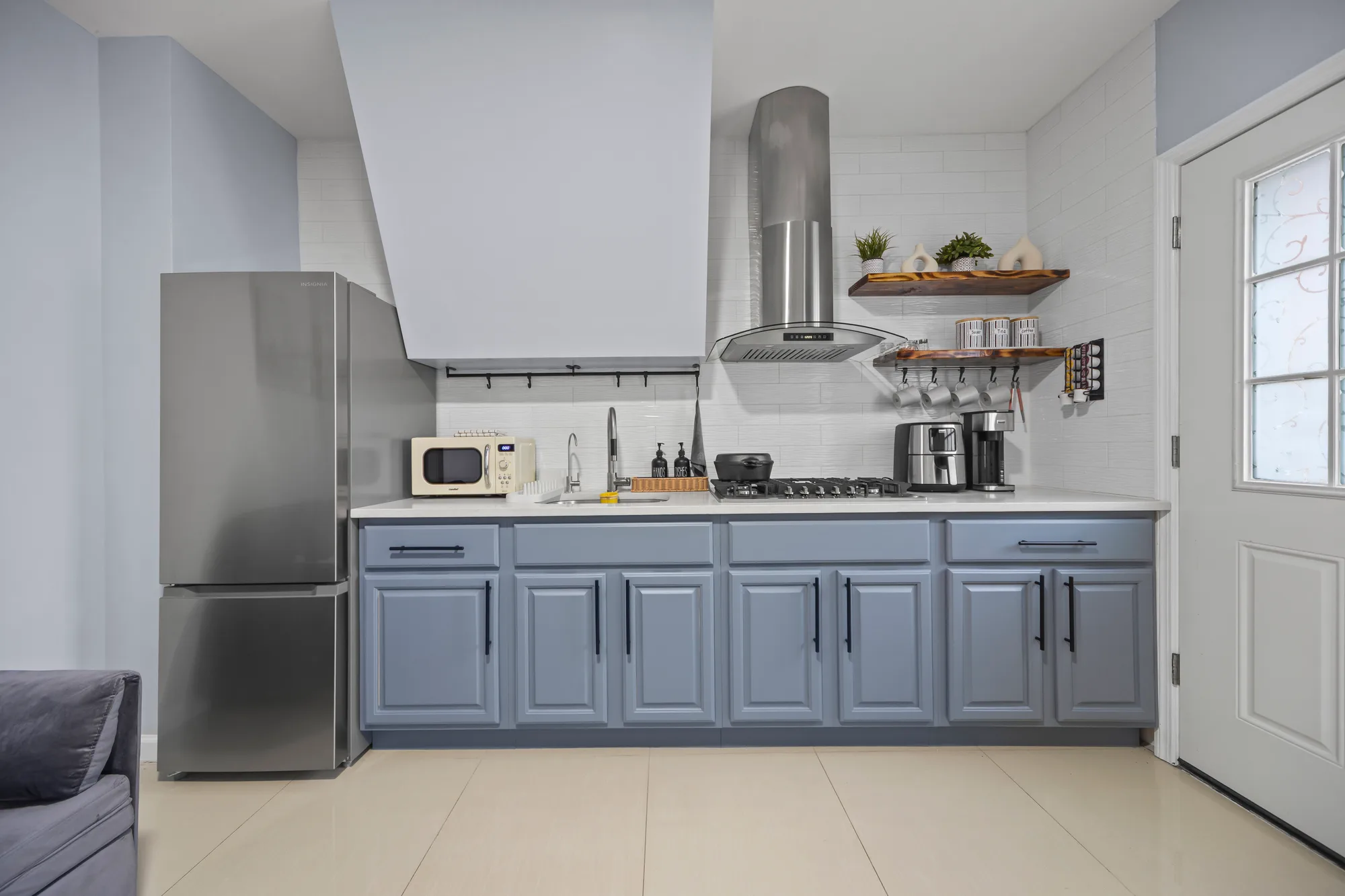Blue cabinet kitchen with stainless appliances, HDR listing photography for a New York City apartment showing accurate color and true geometry