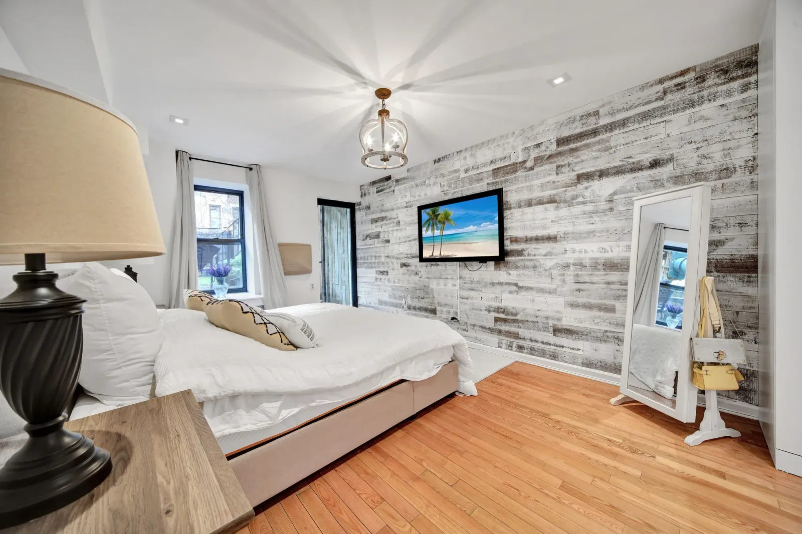 Bedroom with a reclaimed-wood accent wall finished and tone-mapped for a listing in New York City