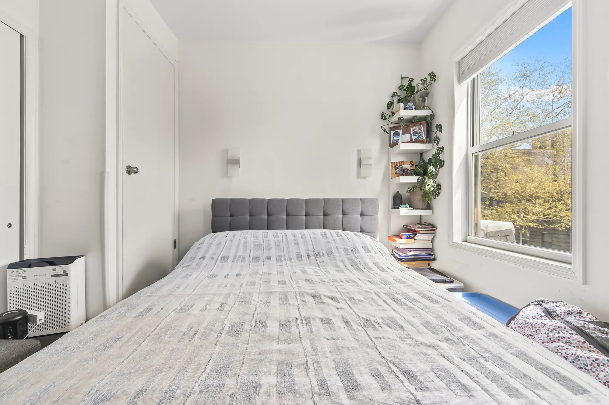 Sunlit bedroom with a window view in a short-term rental, Airbnb photography for the listing in Baltimore