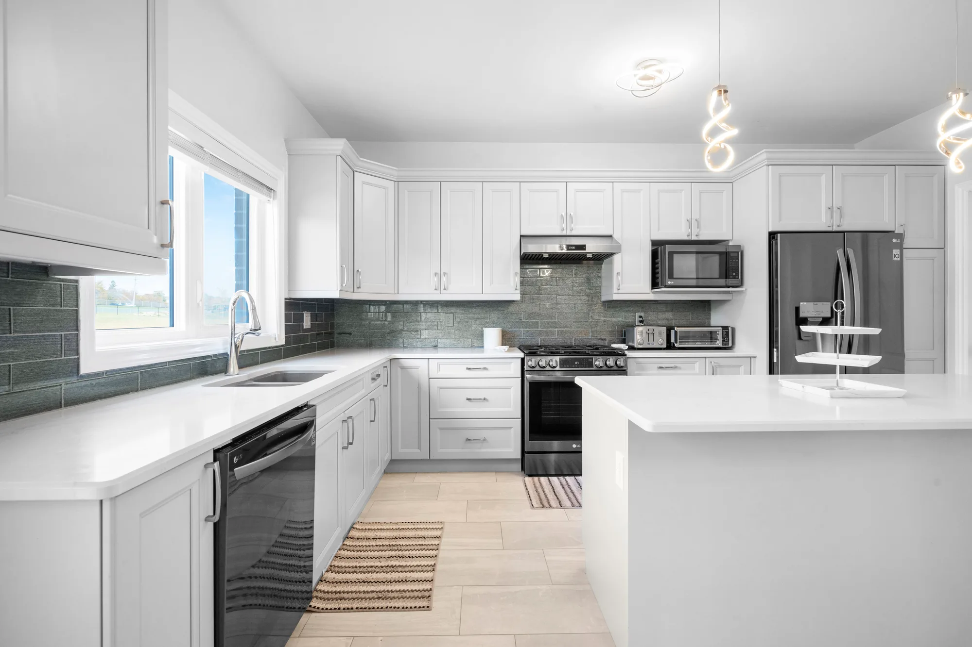 Bright white kitchen with green subway tile backsplash, island, and stainless steel appliances, by OpenDoors360