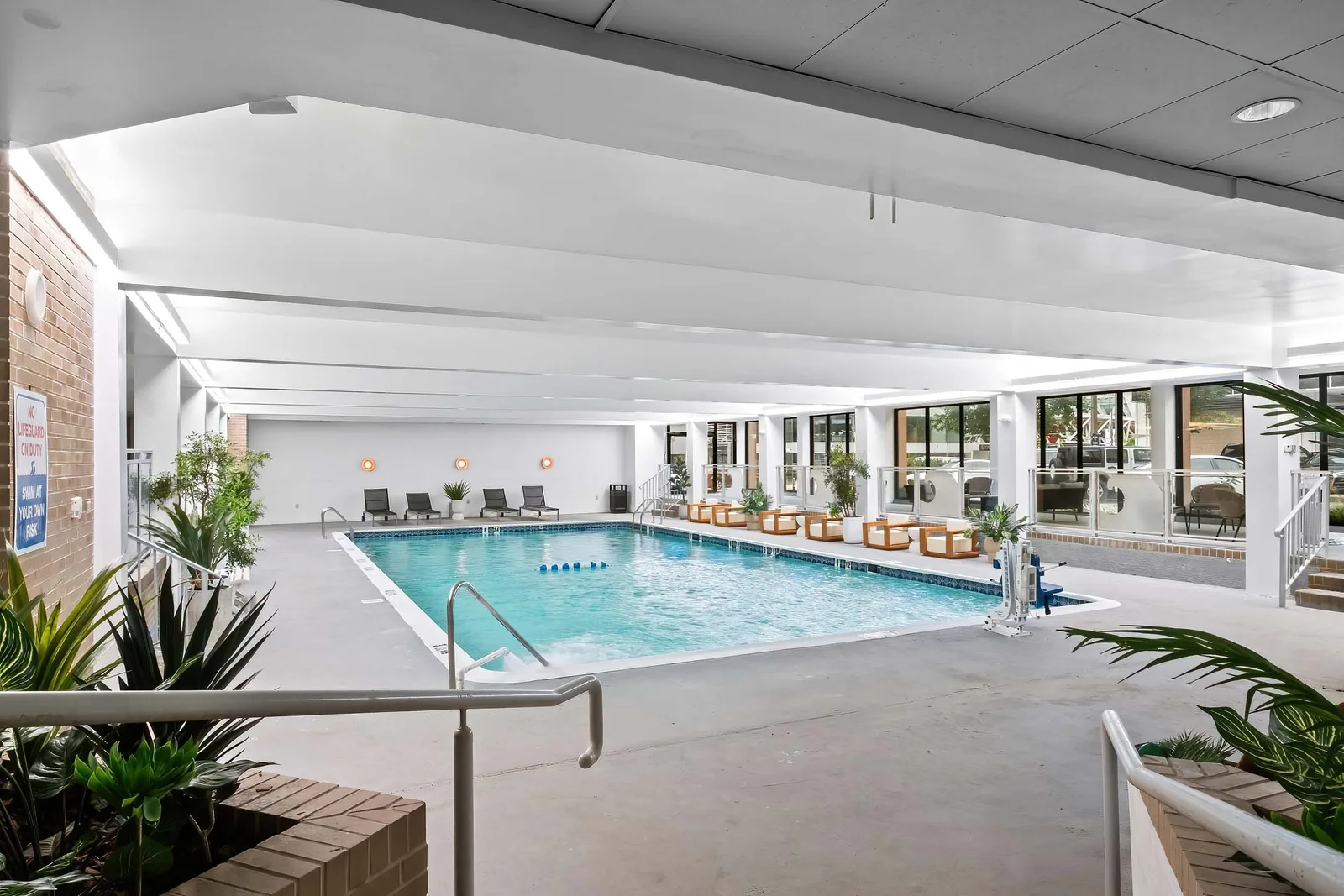Indoor swimming pool amenity with lounge seating and floor-to-ceiling windows, by OpenDoors360