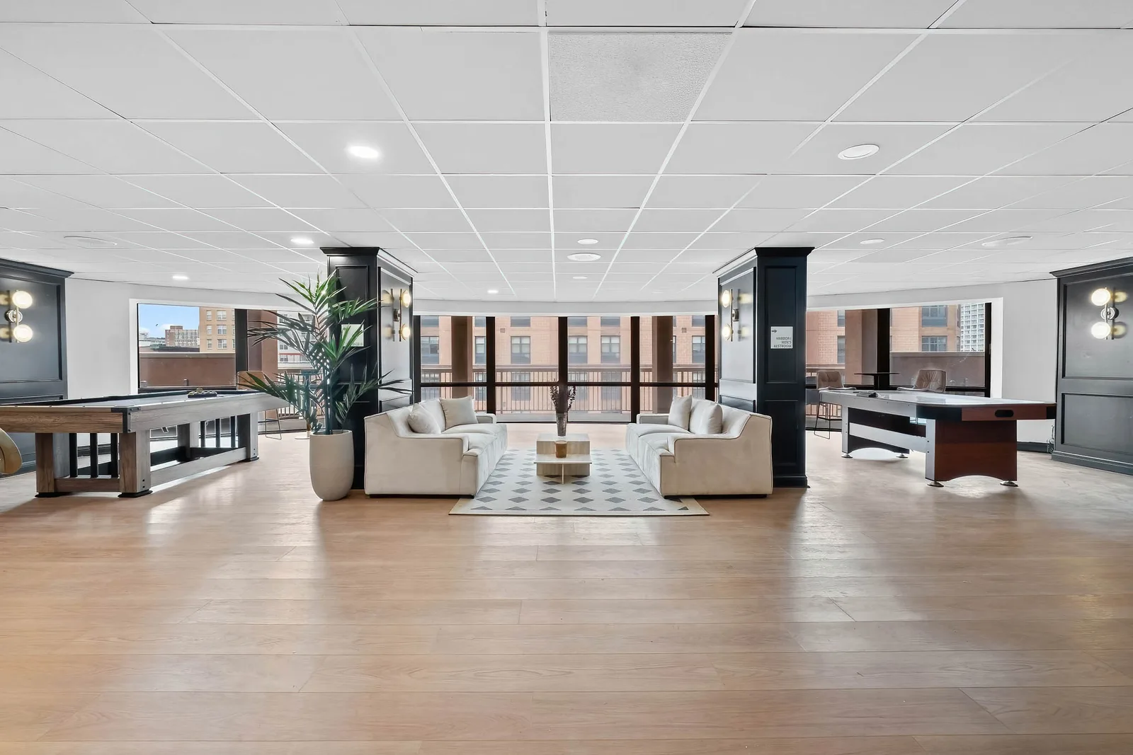 Residential game lounge with billiards, air hockey, and city-view windows, by OpenDoors360