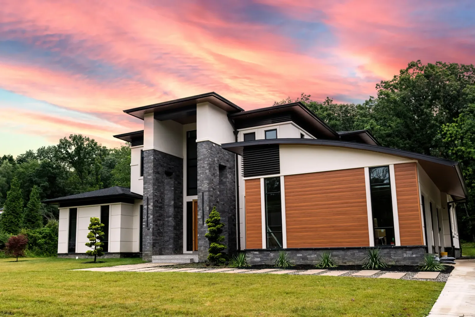 Modern Clifton, VA home exterior with wood siding and stone accents at dusk, by OpenDoors360