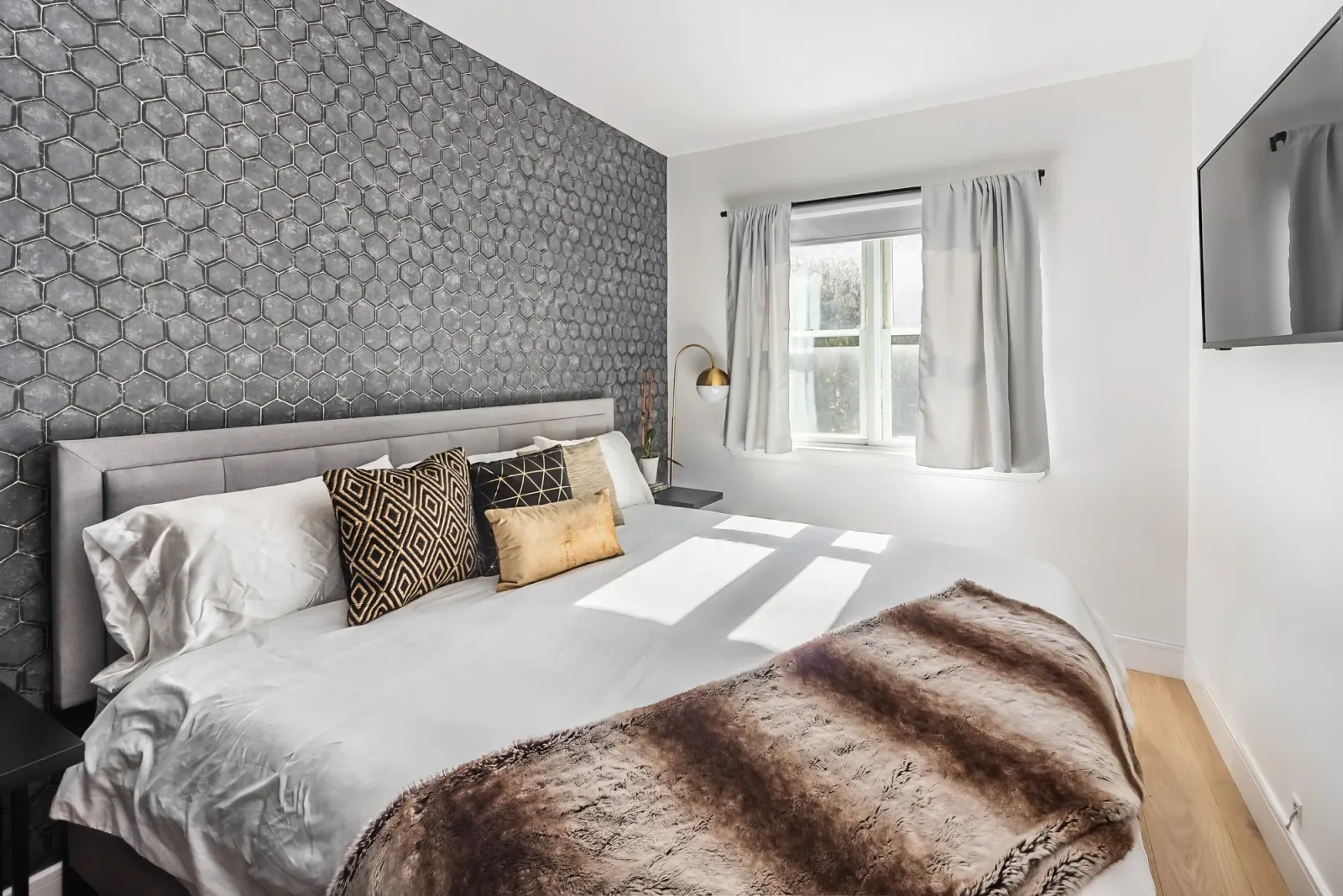 Bedroom with a textured accent wall in a short-term rental, professional photographers deliver high quality images for an Airbnb listing in Baltimore
