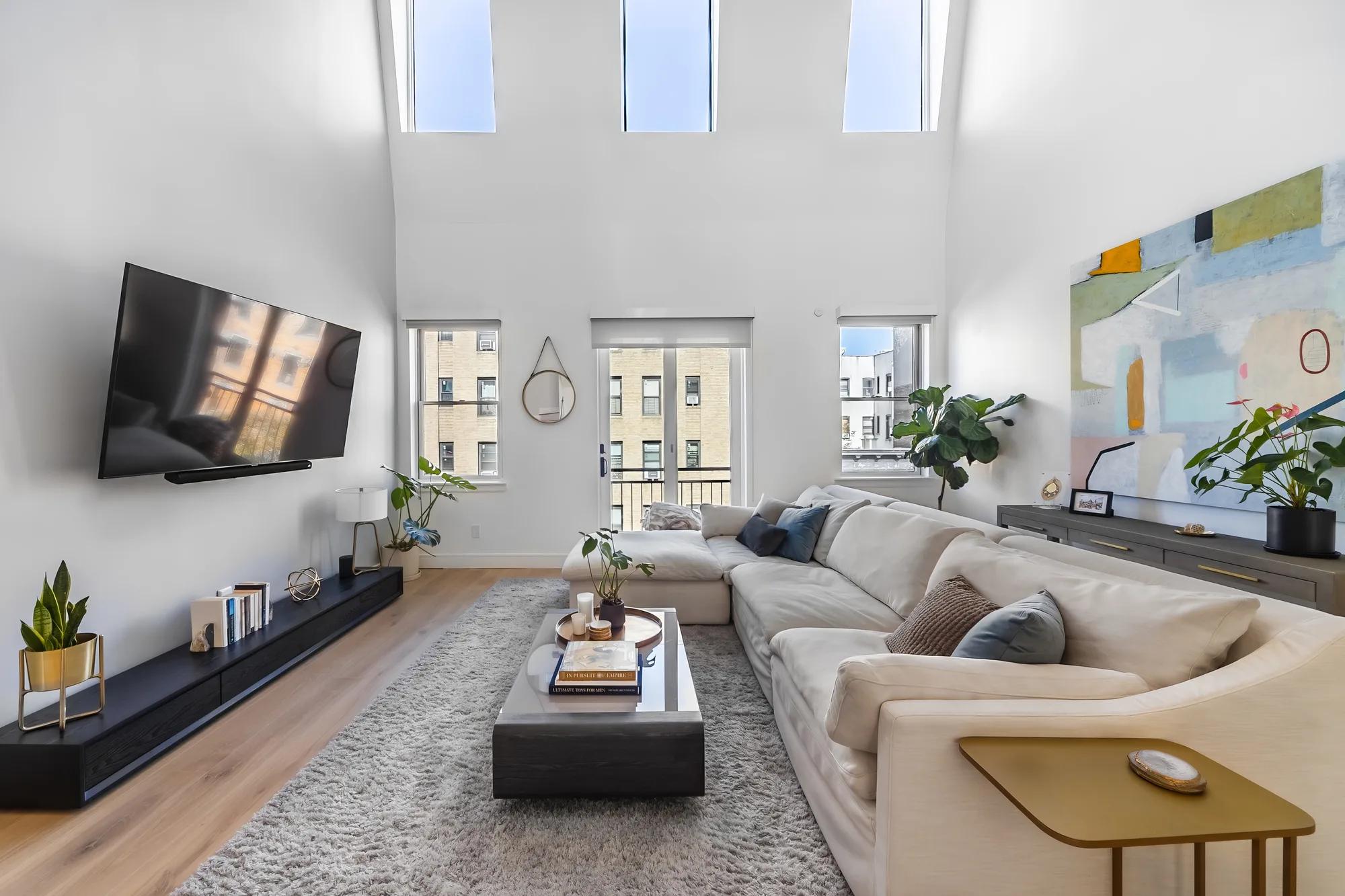 Double-height living room real estate photography with New York City building views, captured for realtors marketing more listings