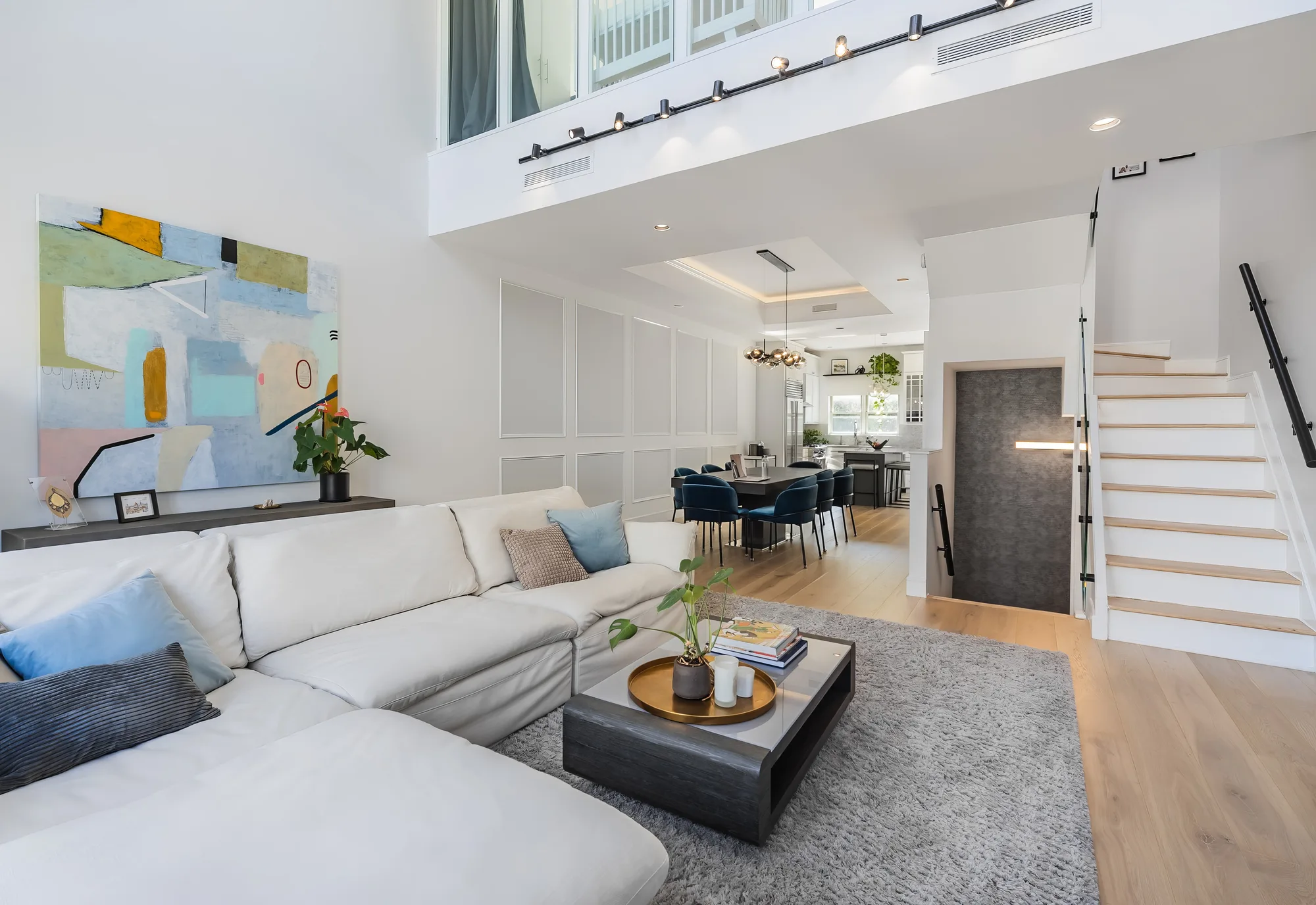 Double-height loft living room with staircase shot for Brooklyn real estate photography, the way a floor plan reads to potential buyers