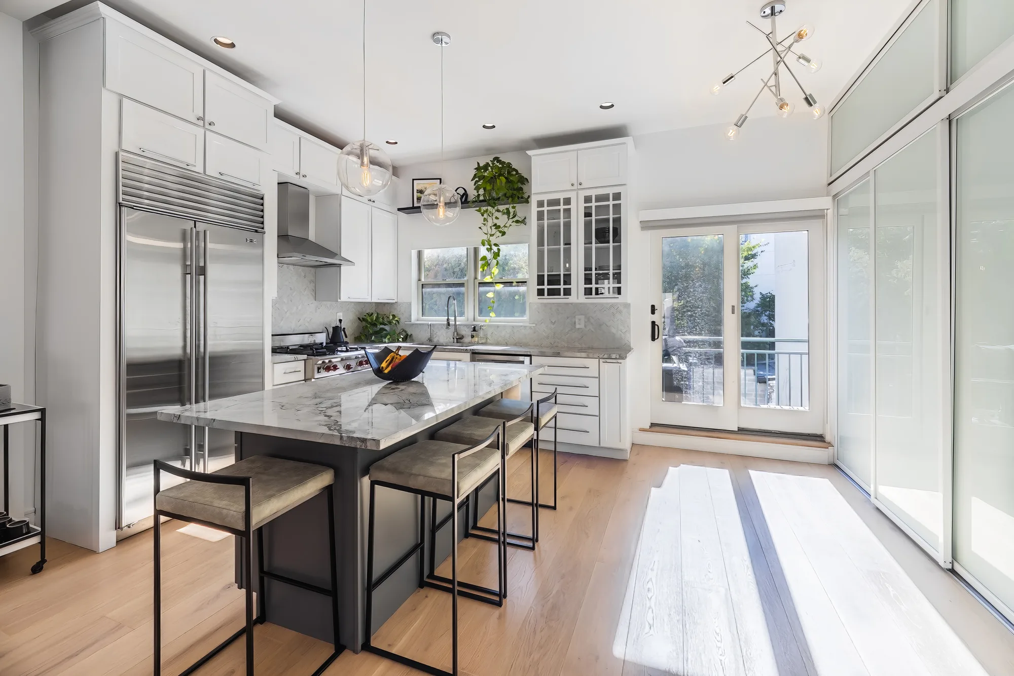 Large kitchen with island and French doors to a deck, interior real estate photography on Staten Island that helps a buyer read the floor plan of a detached home