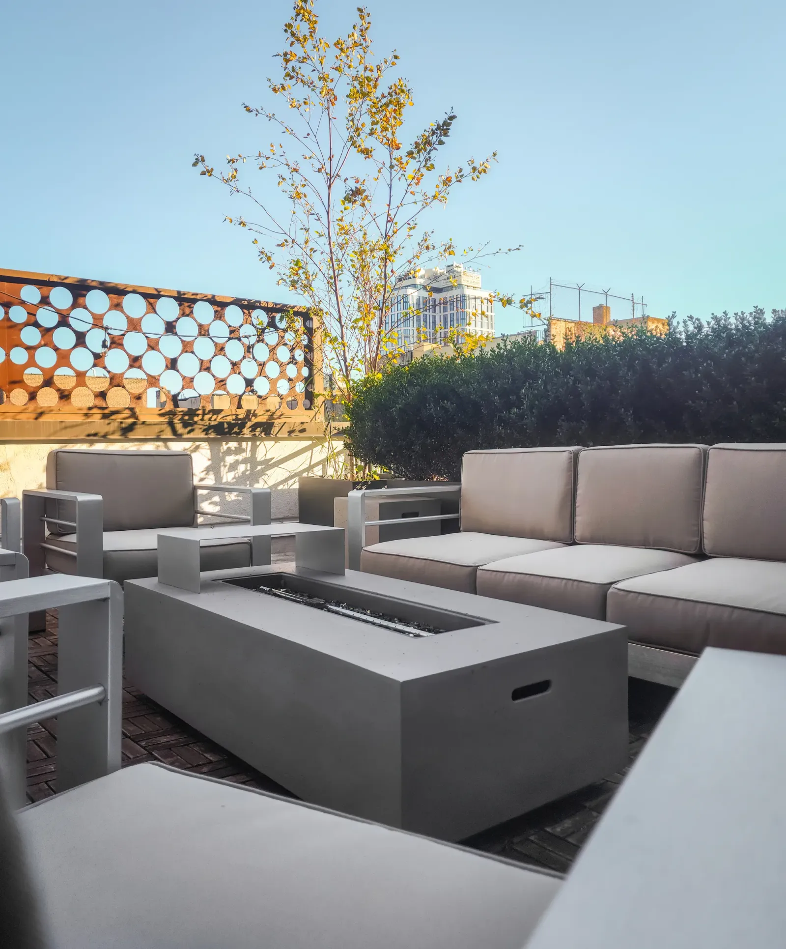 Rooftop terrace with a fire table and city skyline beyond, outdoor real estate photography in New York City