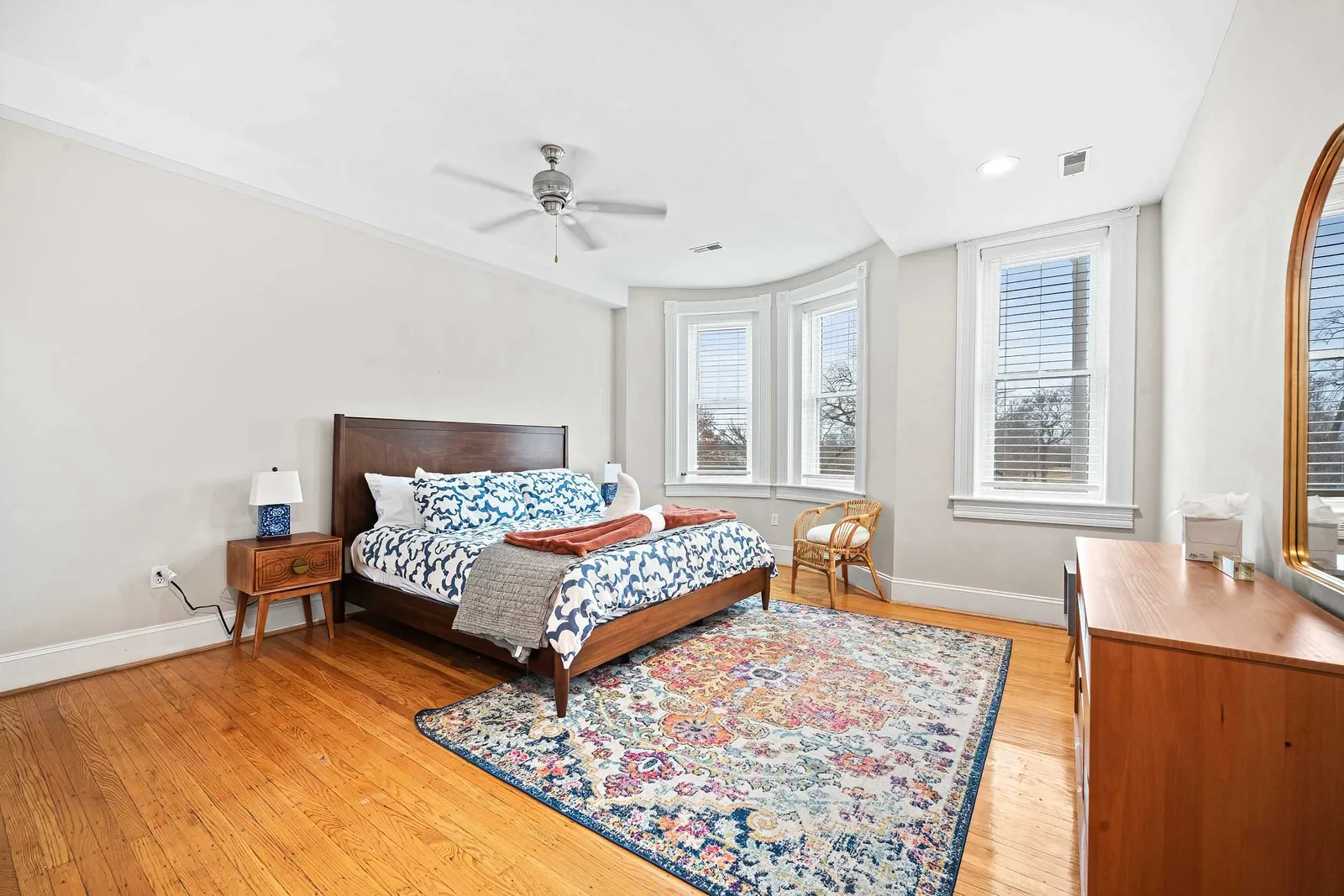 Prewar bedroom with bay windows and hardwood floors, real estate photography for a Bronx single-family listing in New York City