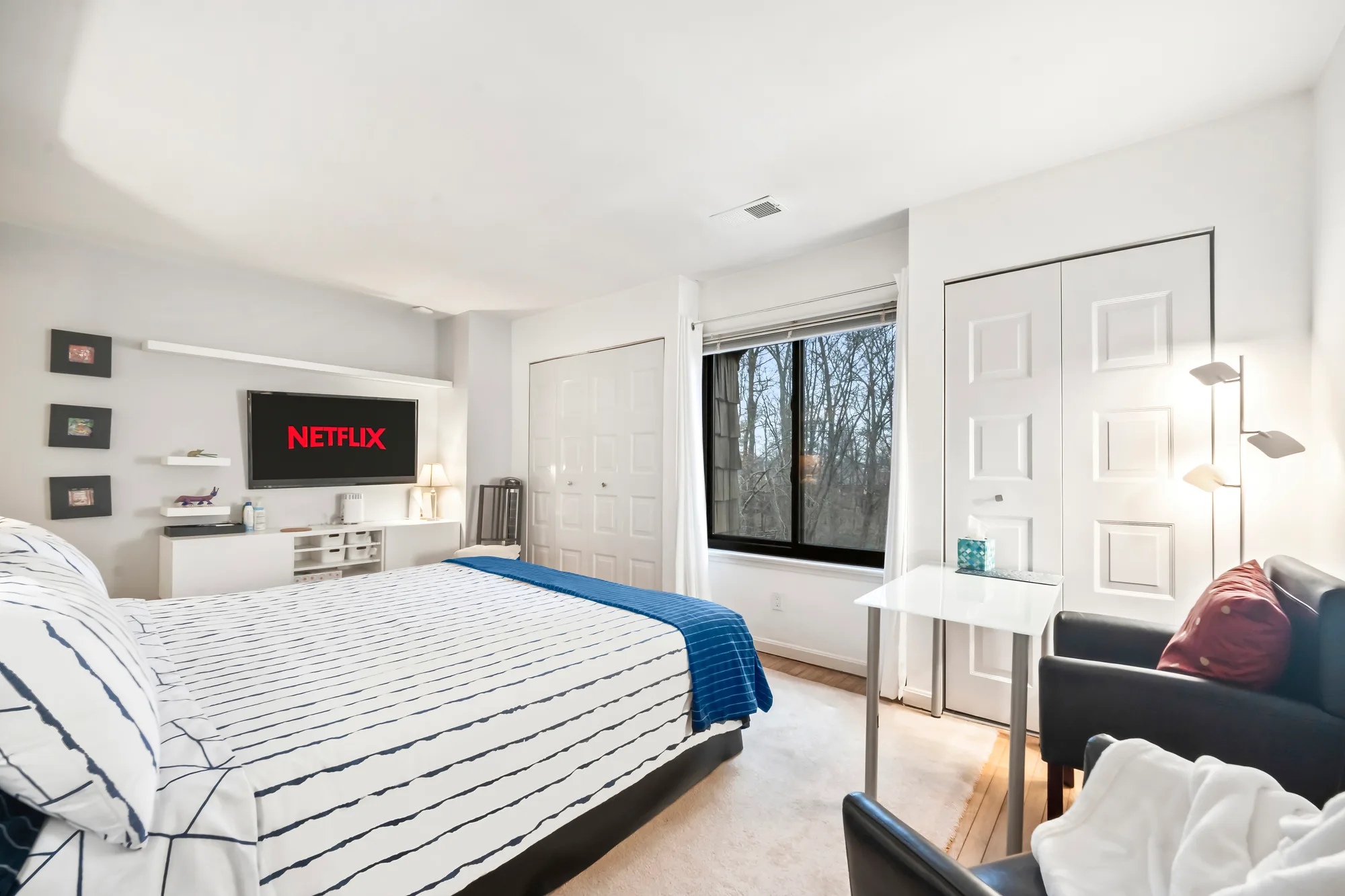 Spacious primary bedroom with woodland views, real estate photography on Staten Island that gives buyers a true sense of room scale alongside the floor plan